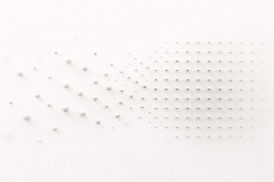 Minimalist abstract illustration showing particles transitioning from a scattered, disordered arrangement into a structured, repeating grid pattern, representing the shift from instability to stable order.